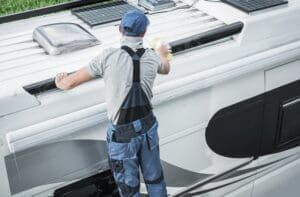 How To Winterize your RV(/how-to-winterize-your-rv/) – Rv service worker cleaning camper van roof 8QZ86NF